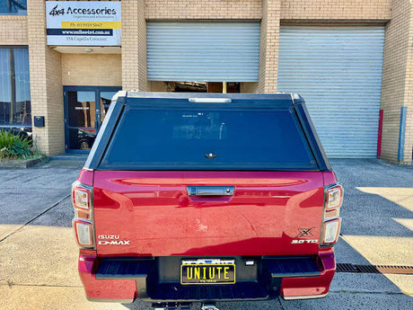 Red vehicle with a custom canopy for ute parked in front of a workshop