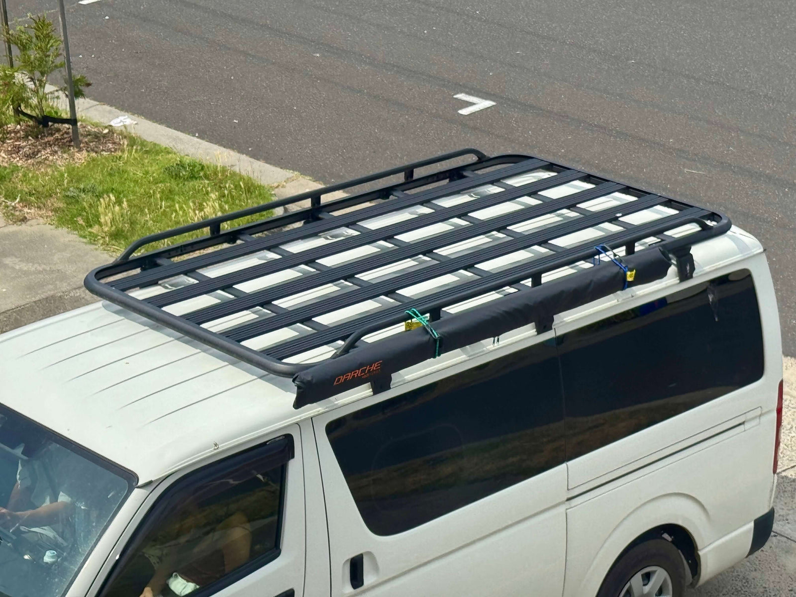 Toyota Hiace roof rack installed securely on a white van, showcasing its sturdy design for optimal storage and transport.