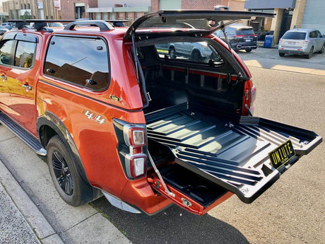 Red vehicle with open 4x4 ute canopies showcasing storage space on street