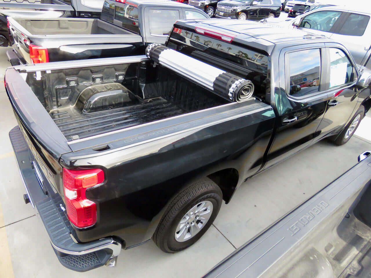 Black pickup truck trucks with open bed on dealership lot for work and adventure needs.