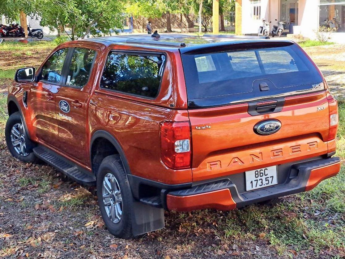 Orange Ford Ranger with Ute Tray Canopy parked outdoors.