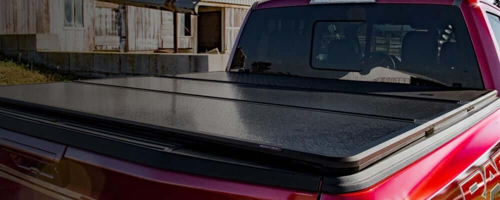 Red ute with UniUte foldable hard lids for secure cargo transport, showcasing sleek and durable design.