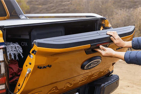 Truck with PROLIFT TAILGATE ASSIST being opened, showcasing easy handling of the tailgate on a rugged vehicle in an outdoor setting.