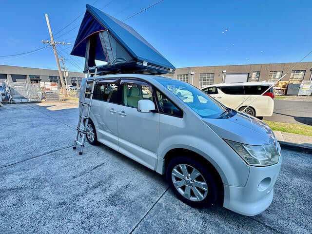 Roof top tent with awning — side view showing streamlined closed profile on vehicle
