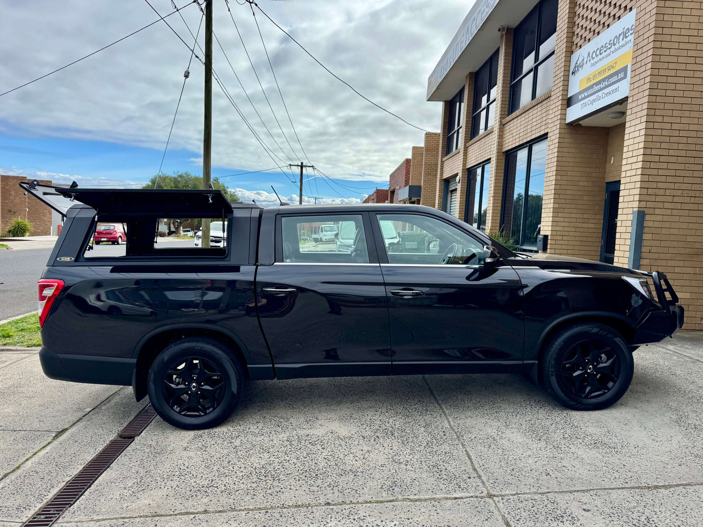 Black KGM Musso Canopy with stainless steel for 2018-2025 XLV Long Tub ute shown on a city street