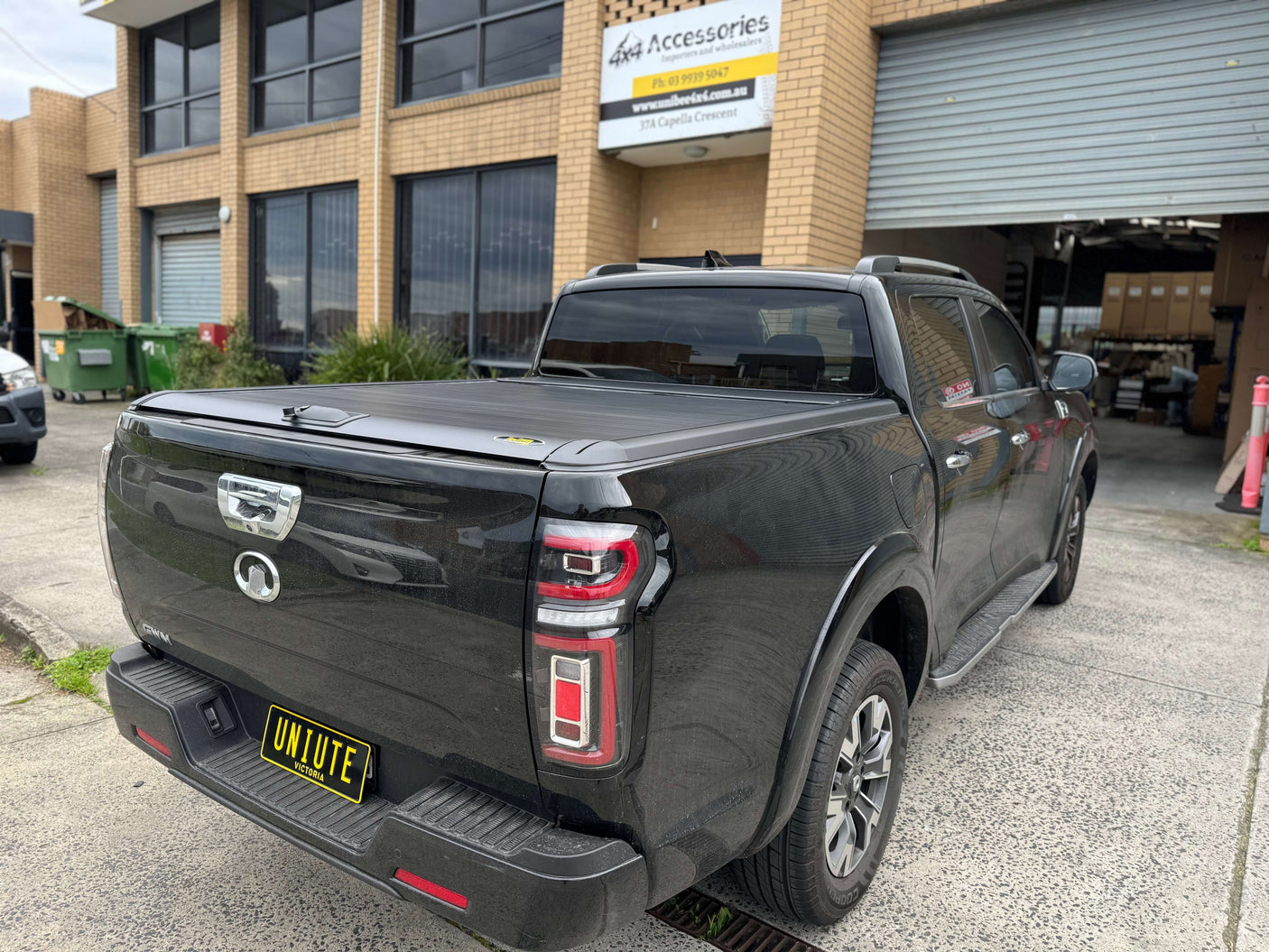 GWM Cannon Roller Shutter by UniUte, 2020-2025 model, parked outside an accessory shop.