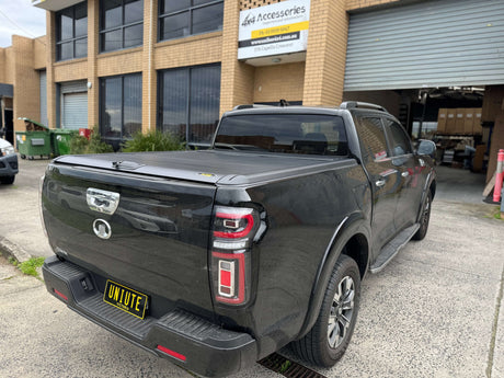 GWM Cannon Roller Shutter by UniUte, 2020-2025 model, parked outside an accessory shop.