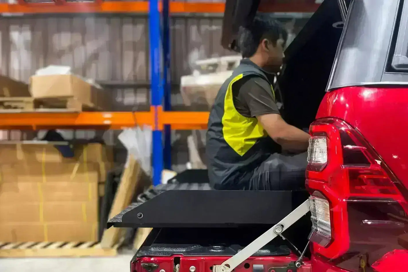 Man using ute slide out tray in a Volkswagen Amarok for enhanced vehicle storage and organization