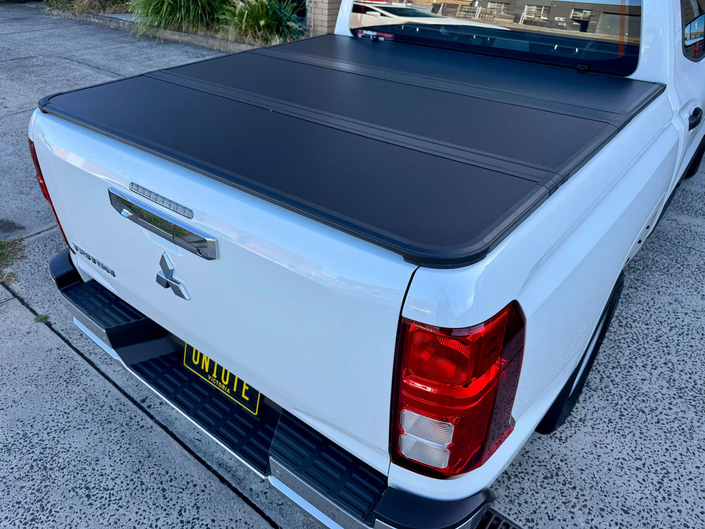 Tonneau Cover Mitsubishi Triton MV 2024+ Tri-Fold Hard Lid providing sleek and durable protection for truck bed.