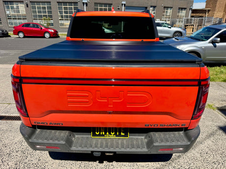 BYD pickup truck featuring a BYD Shark 6 hard lid tri-fold cover, showcasing its fit and utility for 2025+ models.