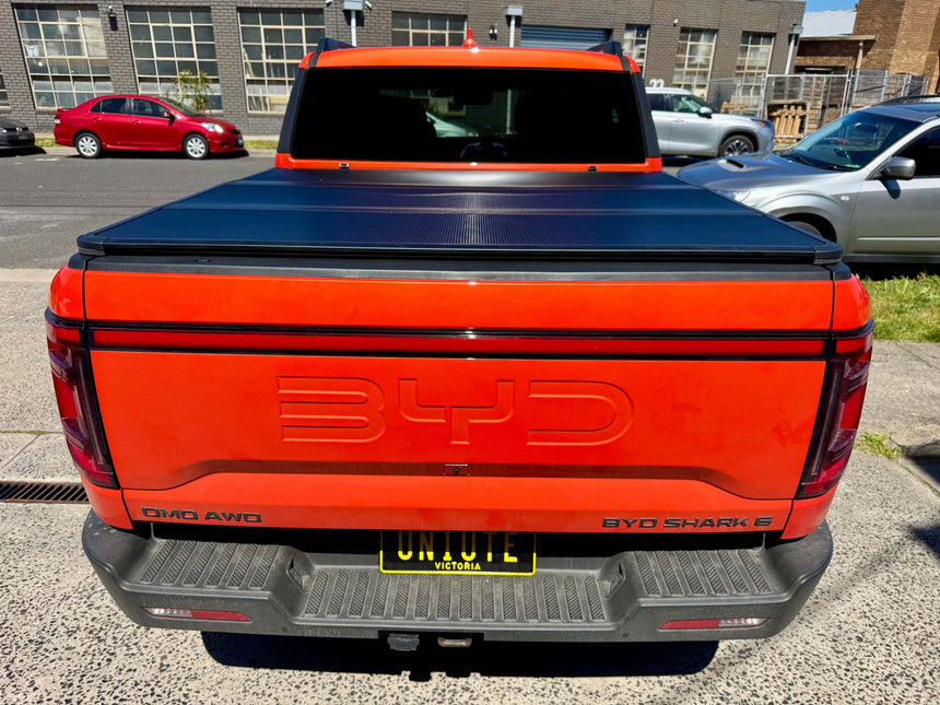 BYD pickup truck featuring a BYD Shark 6 hard lid tri-fold cover, showcasing its fit and utility for 2025+ models.