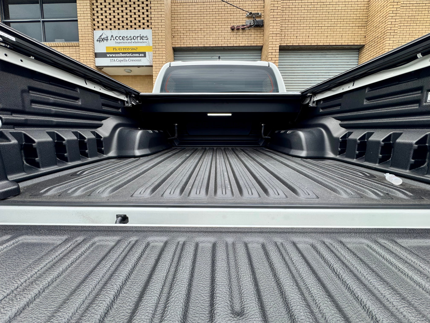 Toyota Hilux N80 N90 roller shutter — control switch and tailgate weather-seal detail