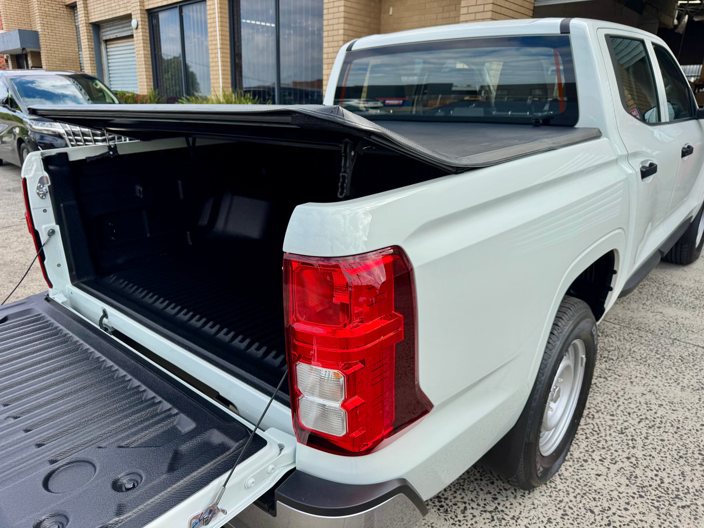 Triton MV 2024+ soft tri-fold cover — panel folded showing tub access