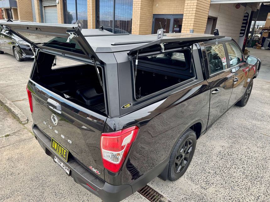 KGM Musso Canopy XLV Long Tub 2018-2025 stainless steel ute canopy displayed on a black truck at UniUte garage.