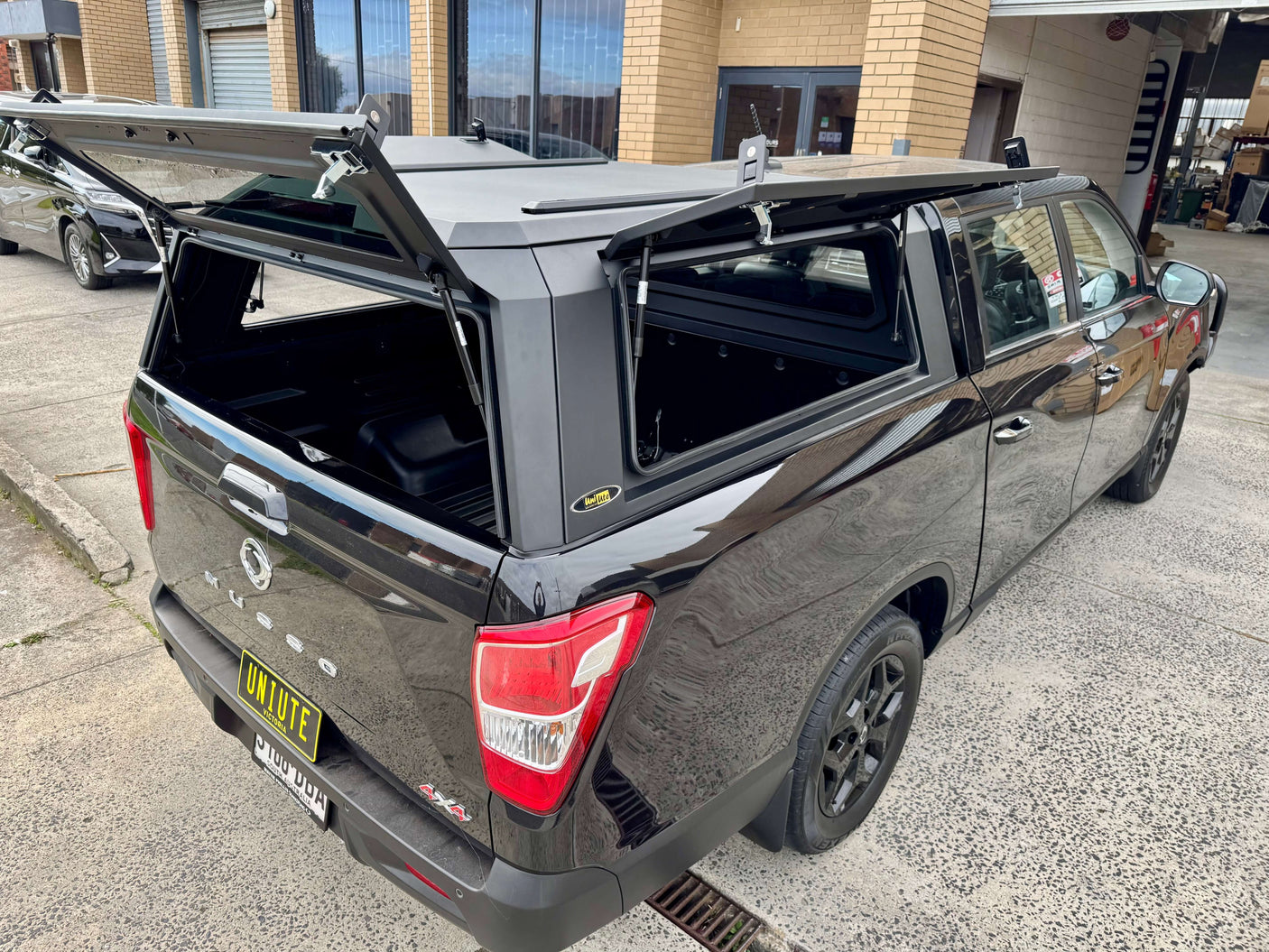 KGM Musso Canopy XLV Long Tub 2018-2025 stainless steel ute canopy displayed on a black truck at UniUte garage.