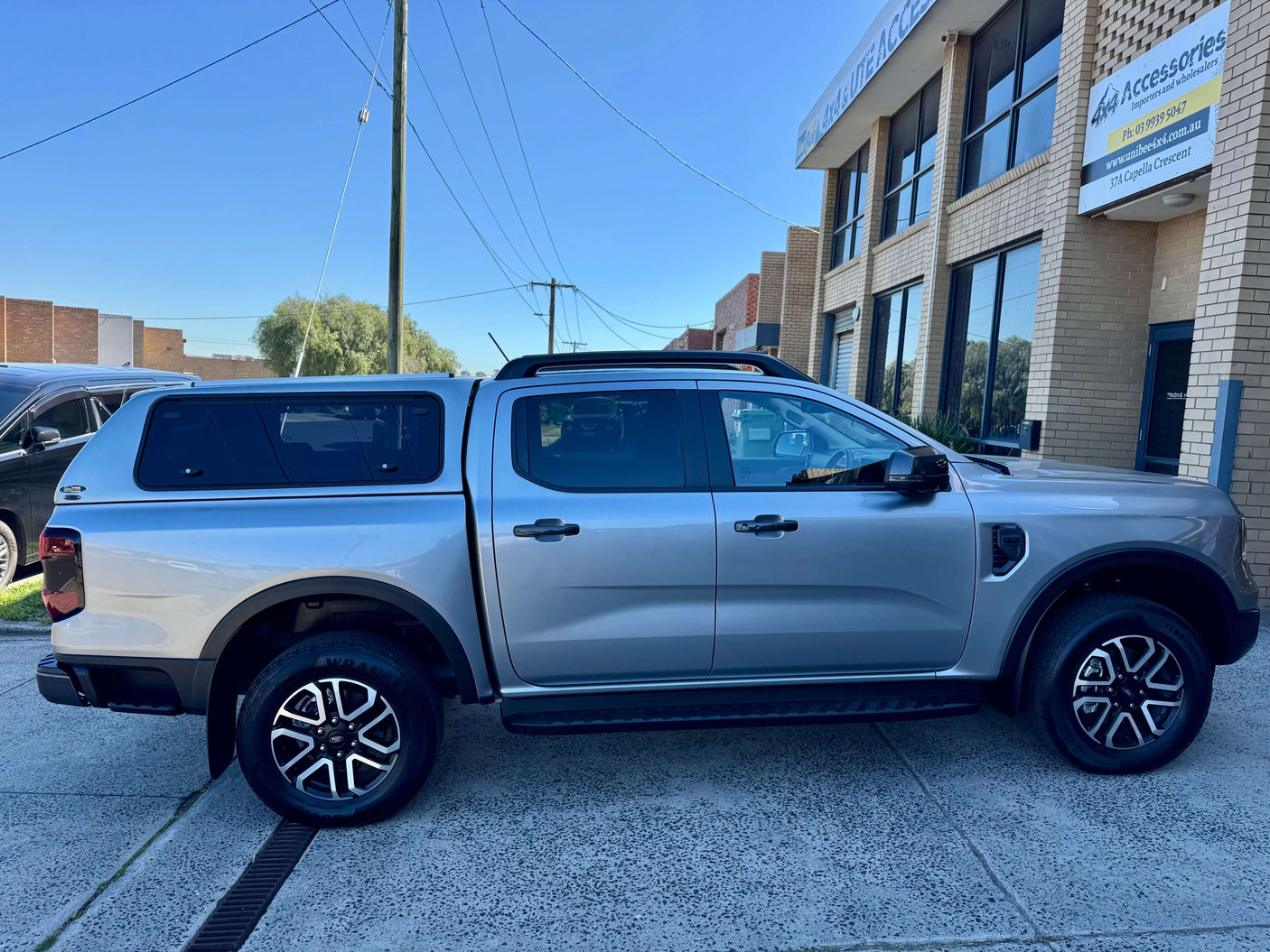 Ford Ranger canopy parked outside a storefront, showcasing versatility and style.