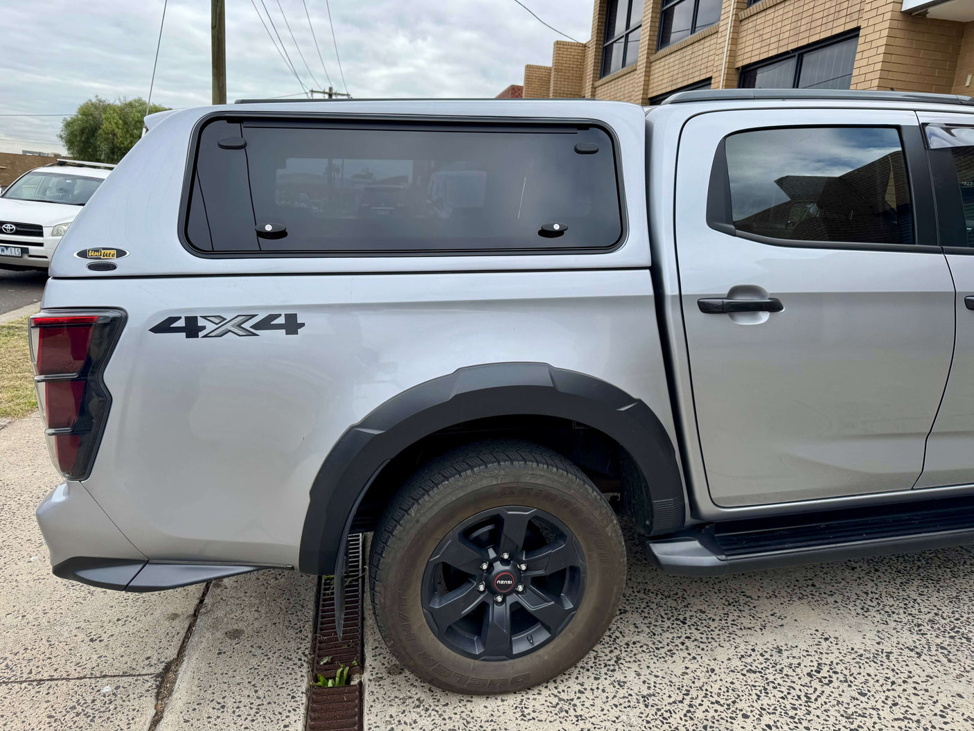 Side view of silver Isuzu D-Max with FORCE PRO canopy dmax 2020-2025 installed, parked on a concrete surface.