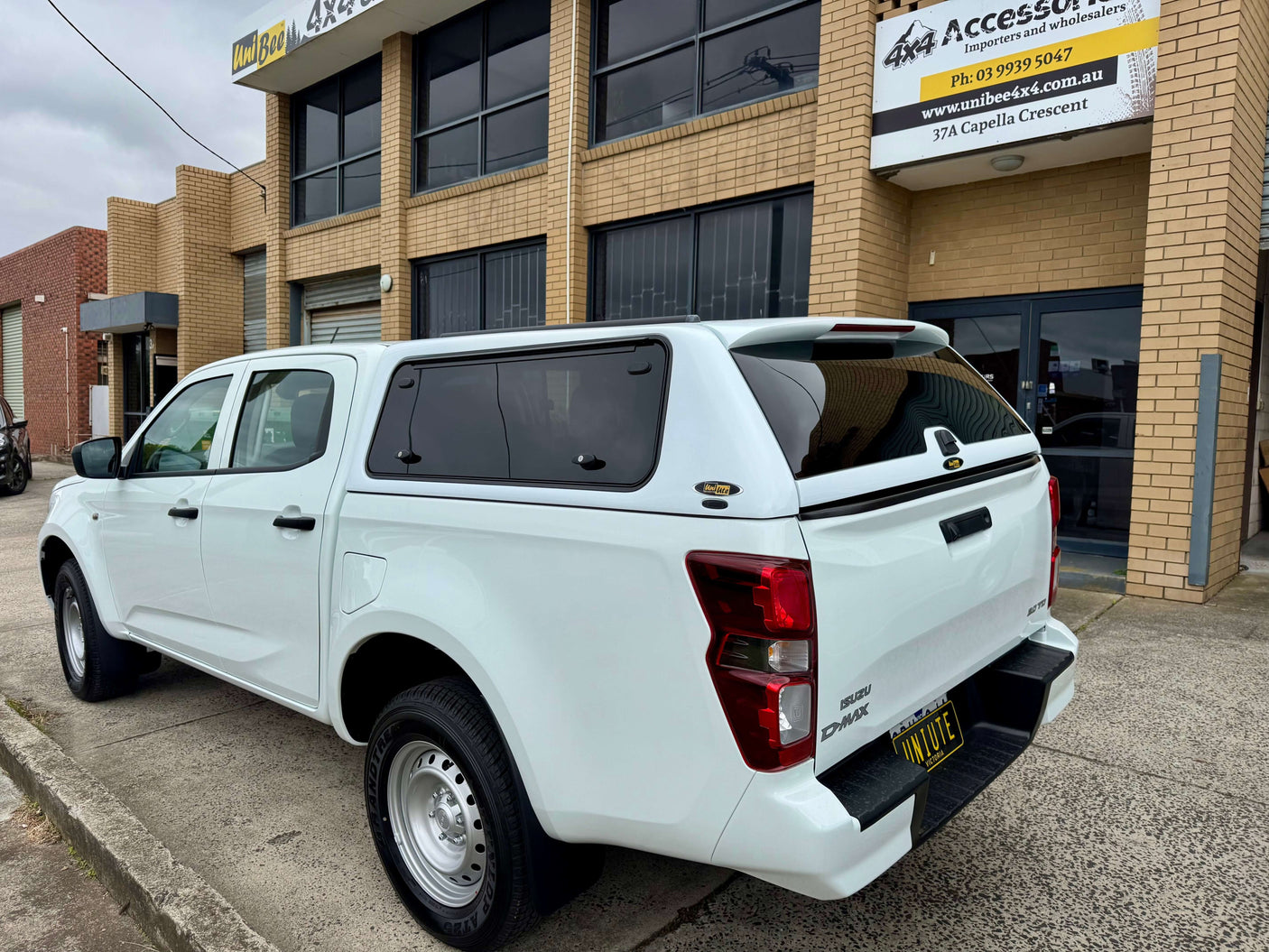 Isuzu D-Max dual cab with FORCE PRO canopy DMax 2020-2025, parked outside a building, showcasing rugged design and durability.
