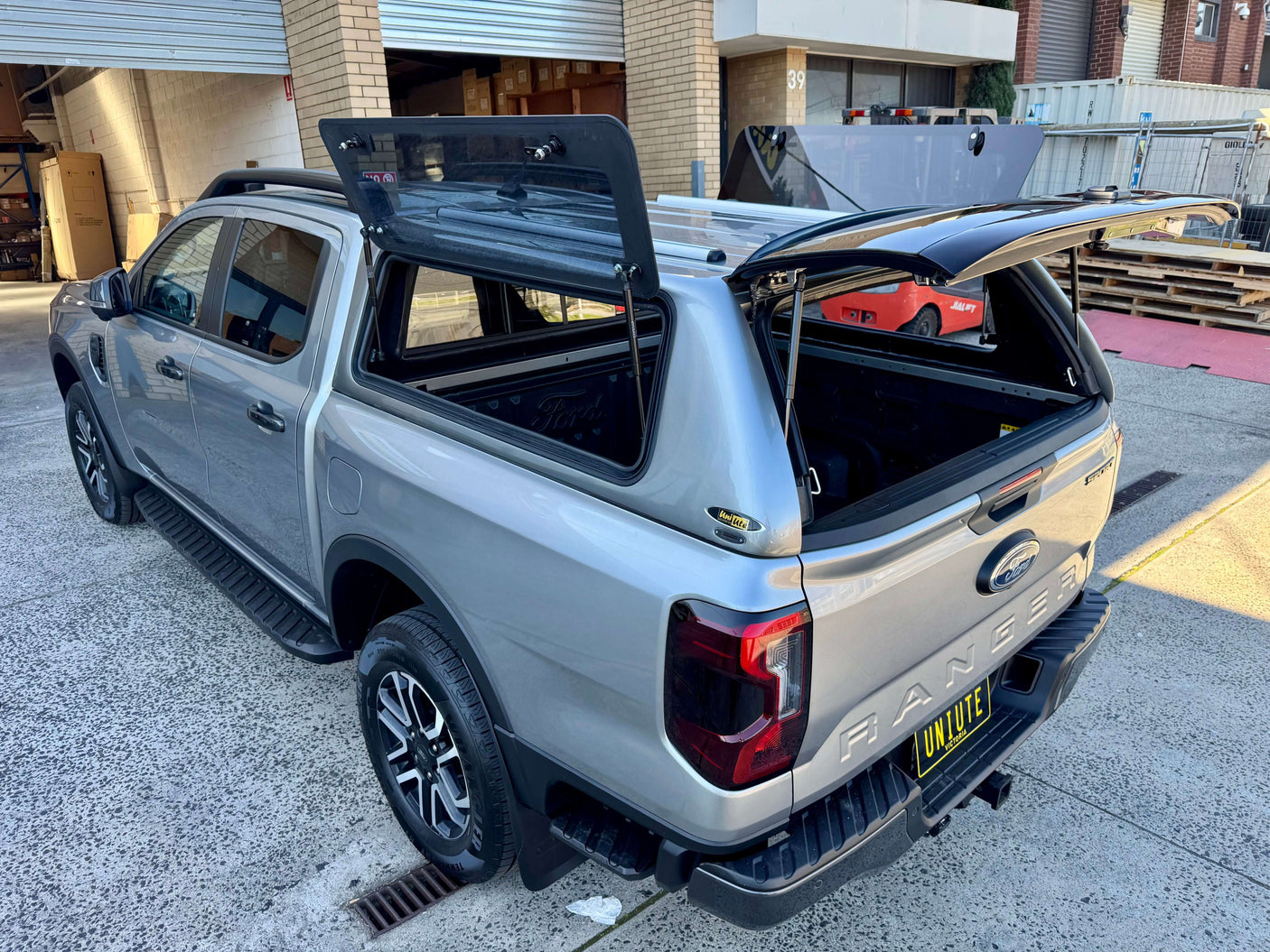 Silver Ford Ranger canopy for RA NextGen 2022-2025 showcasing rear and side views on an urban street.