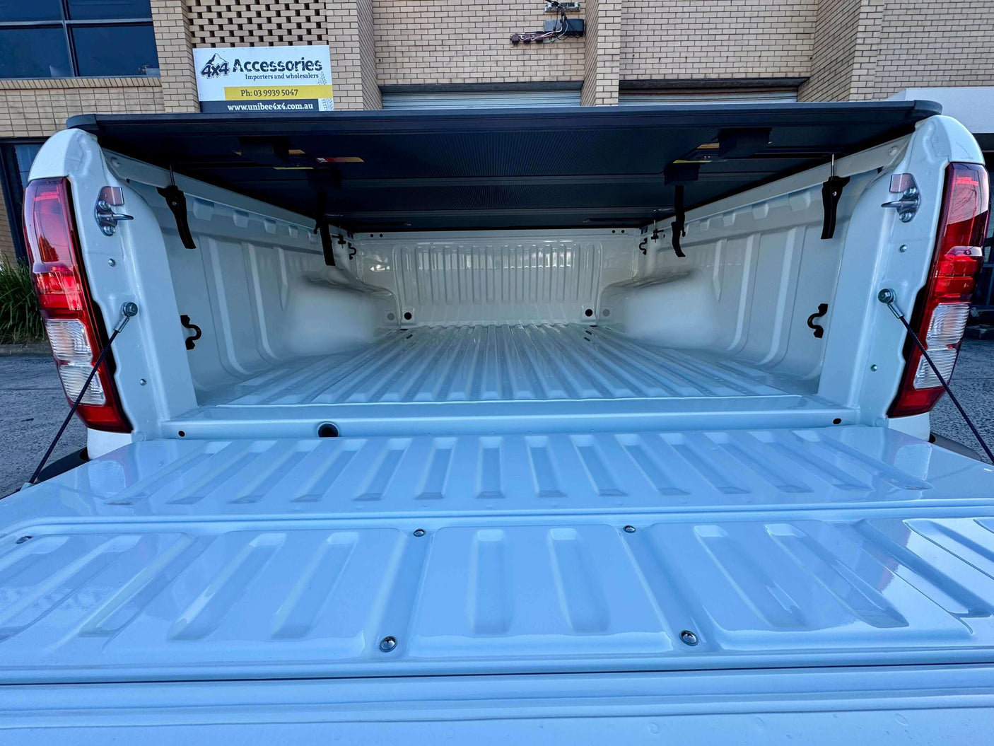 Open truck bed showcasing the tonneau cover Mitsubishi Triton MV 2024+ Tri-Fold Hard Lid for maximum protection and versatility.