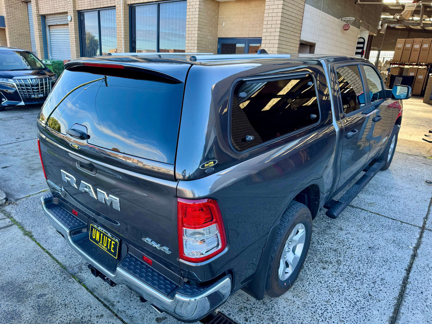 Grey RAM 1500 canopy installed, designed for RAM 1500 DT 2020β2025, showing rear view.