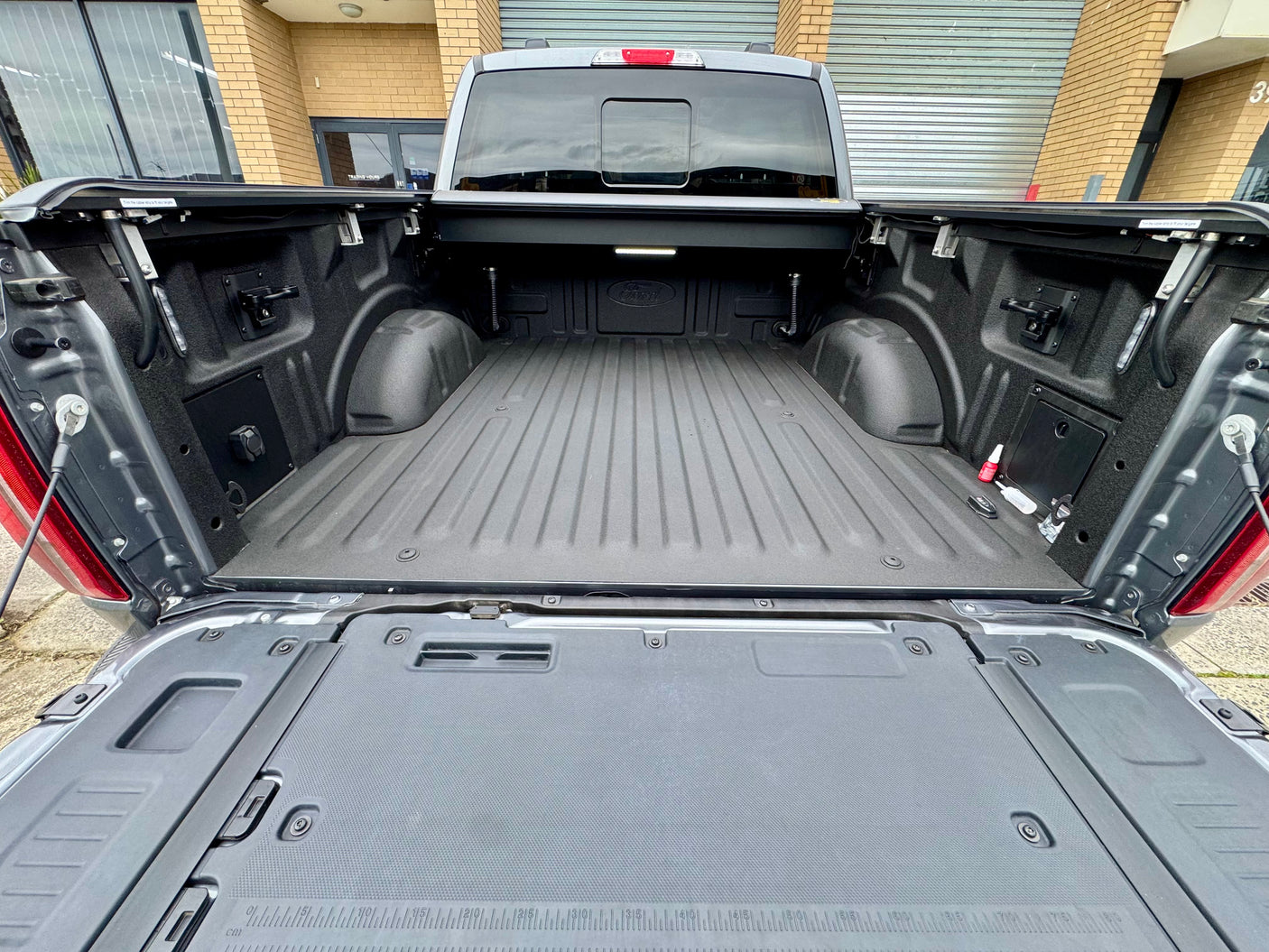 Electric roller shutter for Ford F-150 5'5" bed — half-open position showing motorised operation