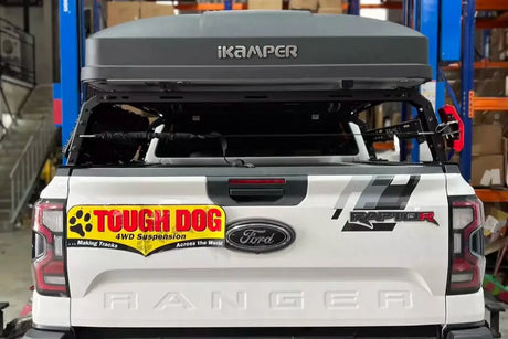 Universal tub rack on a white ute carrying gear securely.