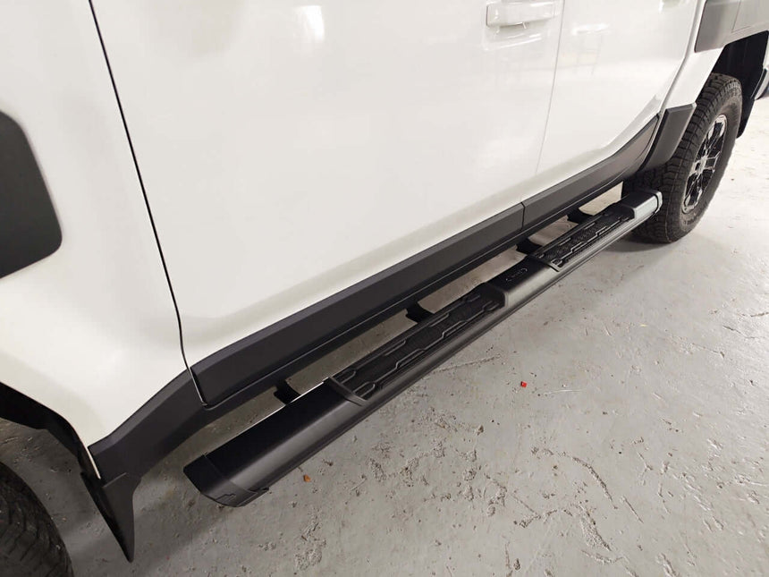 Close-up of KIA Tasman side steps 2025+, black steel side bars on a white vehicle for enhanced access and style