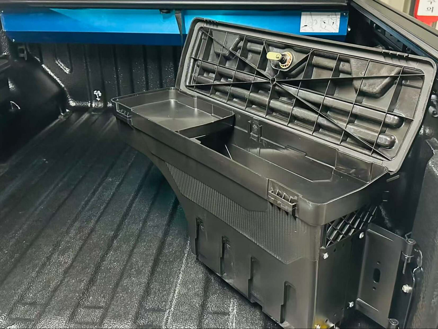 Open Mitsubishi Triton Tool Box installed in a 2024 MV model, showcasing smart swing-out storage for increased access and security.
