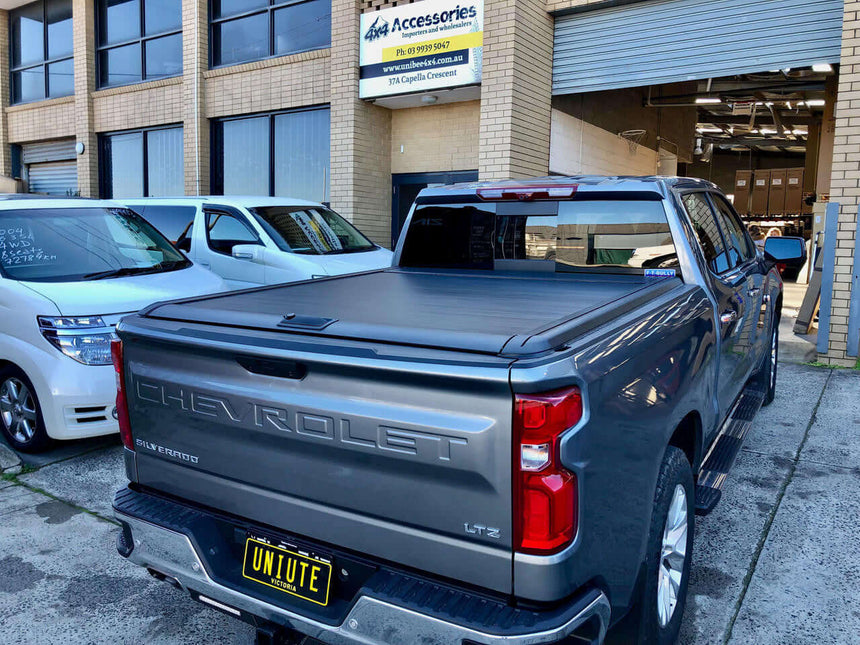 Chevrolet Silverado 1500 with UniUte Gen2 Manual Roller Shutter, parked in front of a store, showcasing silverado 1500 roller shutter.