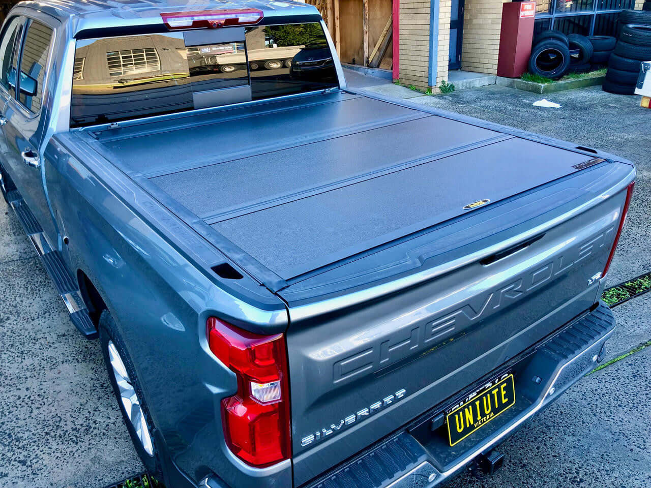 Chevrolet Silverado 1500 with quad-fold hard lid — side view showing four-panel profile