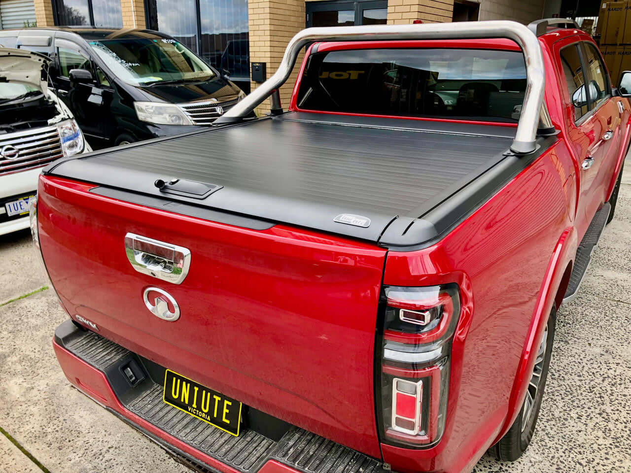 Red truck with UniUte EGen2 Electric Black gwm cannon roller cover 2020-2025 installed, showcasing sleek and secure design.