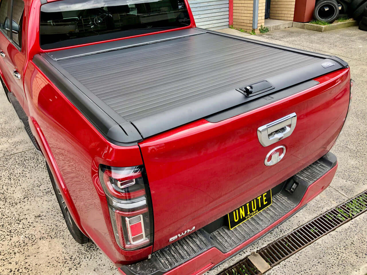 Red GWM ute equipped with EGen2 gwm cannon roller cover for 2020-2025 models, featuring an electric black roller shutter by UniUte.