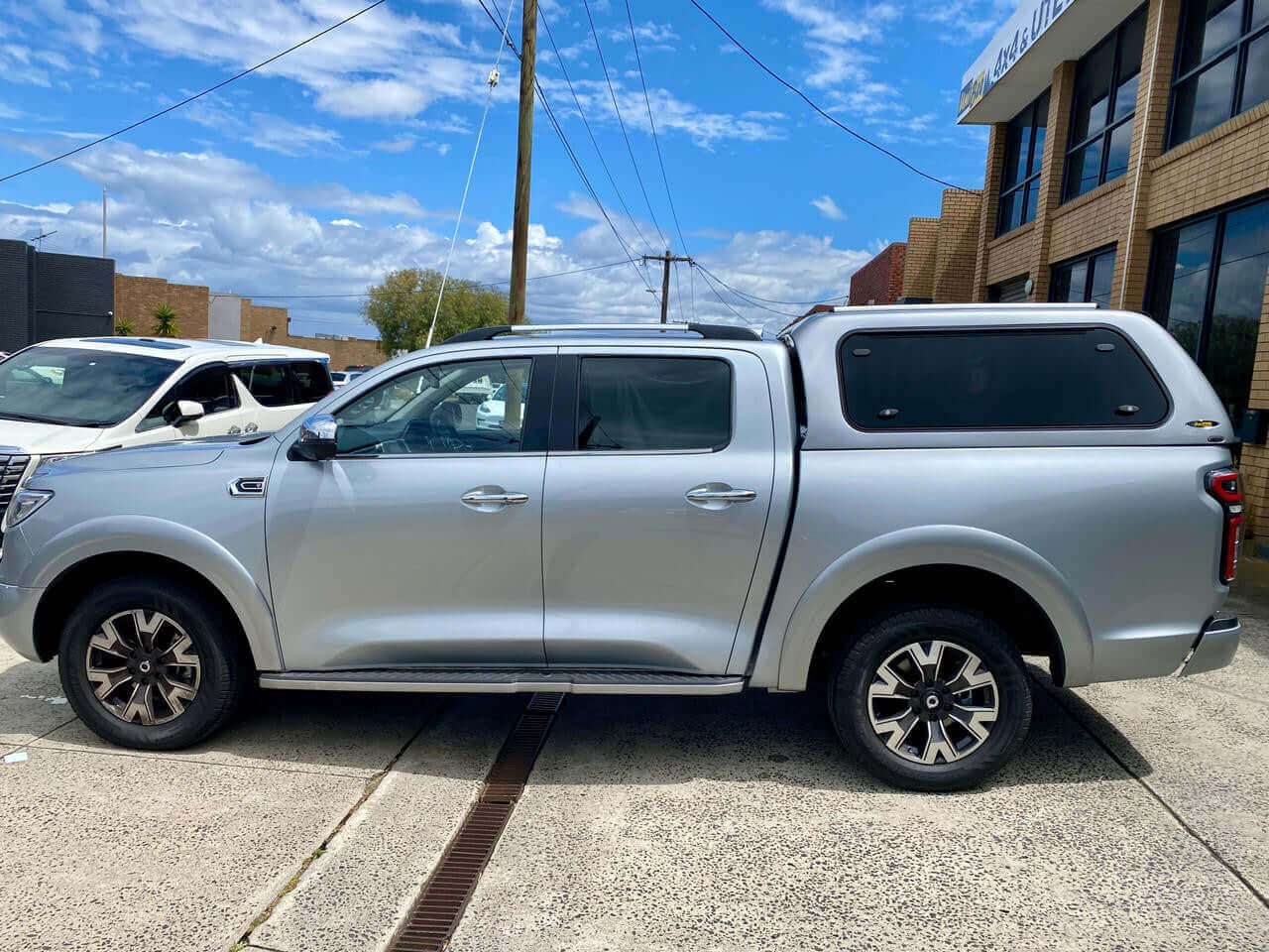 Silver GWM Cannon canopy, 2020-2025 model, parked outside a building under a clear blue sky.