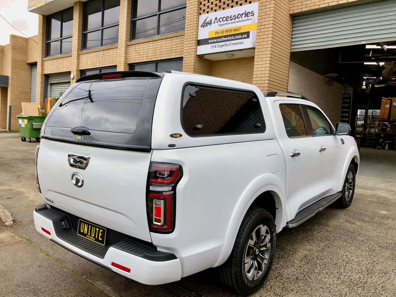 White GWM Cannon canopy parked outside shop.