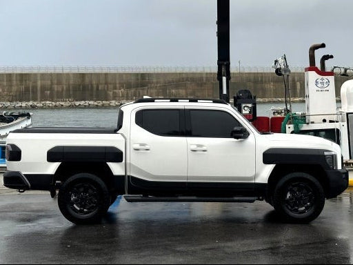 White pickup truck with Kia Tasman roller shutter parked by dockside machinery.