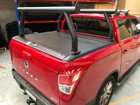 Red ute with ladder racks for roller shutters Gen1 & Gen2 mounted on the back for carrying ladders and long items securely.