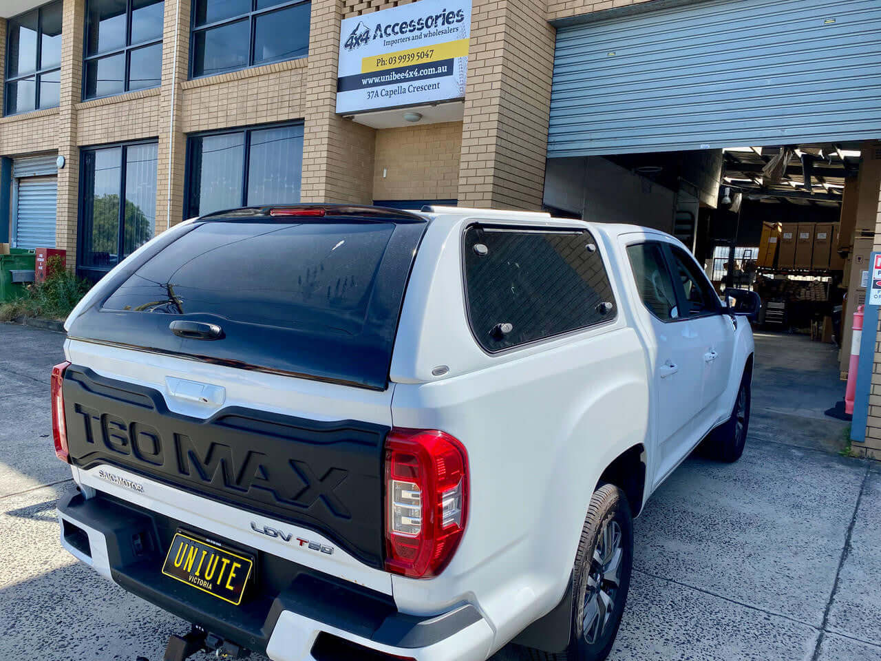 White truck with UniUte FORCE PRO ldv t60 canopy parked outside accessories store.