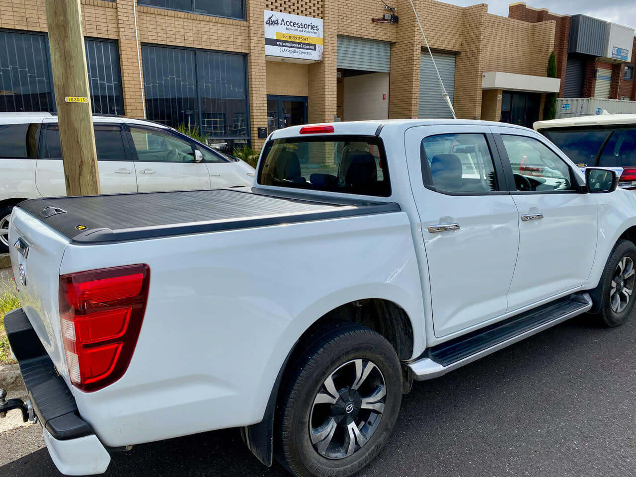White Mazda BT50 with Gen2 manual roller cover parked on street, showcasing style and durability of bt50 roller shutter accessory.