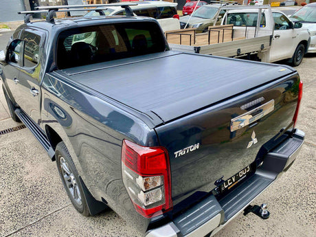 Mitsubishi Triton with UniUte EGen2 Electric Black triton roller lid for MQ & MR 2015-2024 in a parking lot.