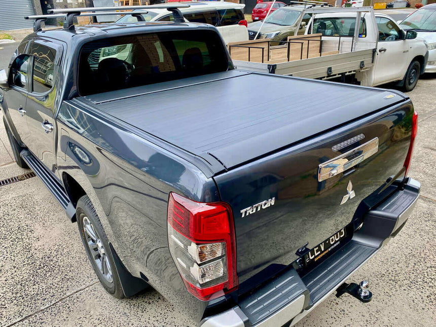 Mitsubishi Triton with UniUte EGen2 Electric Black triton roller lid for MQ & MR 2015-2024 in a parking lot.