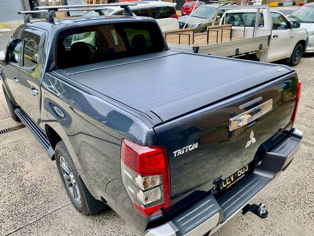 Mitsubishi Triton with UniUte EGen2 Electric Black triton roller lid for MQ & MR 2015-2024 in a parking lot.