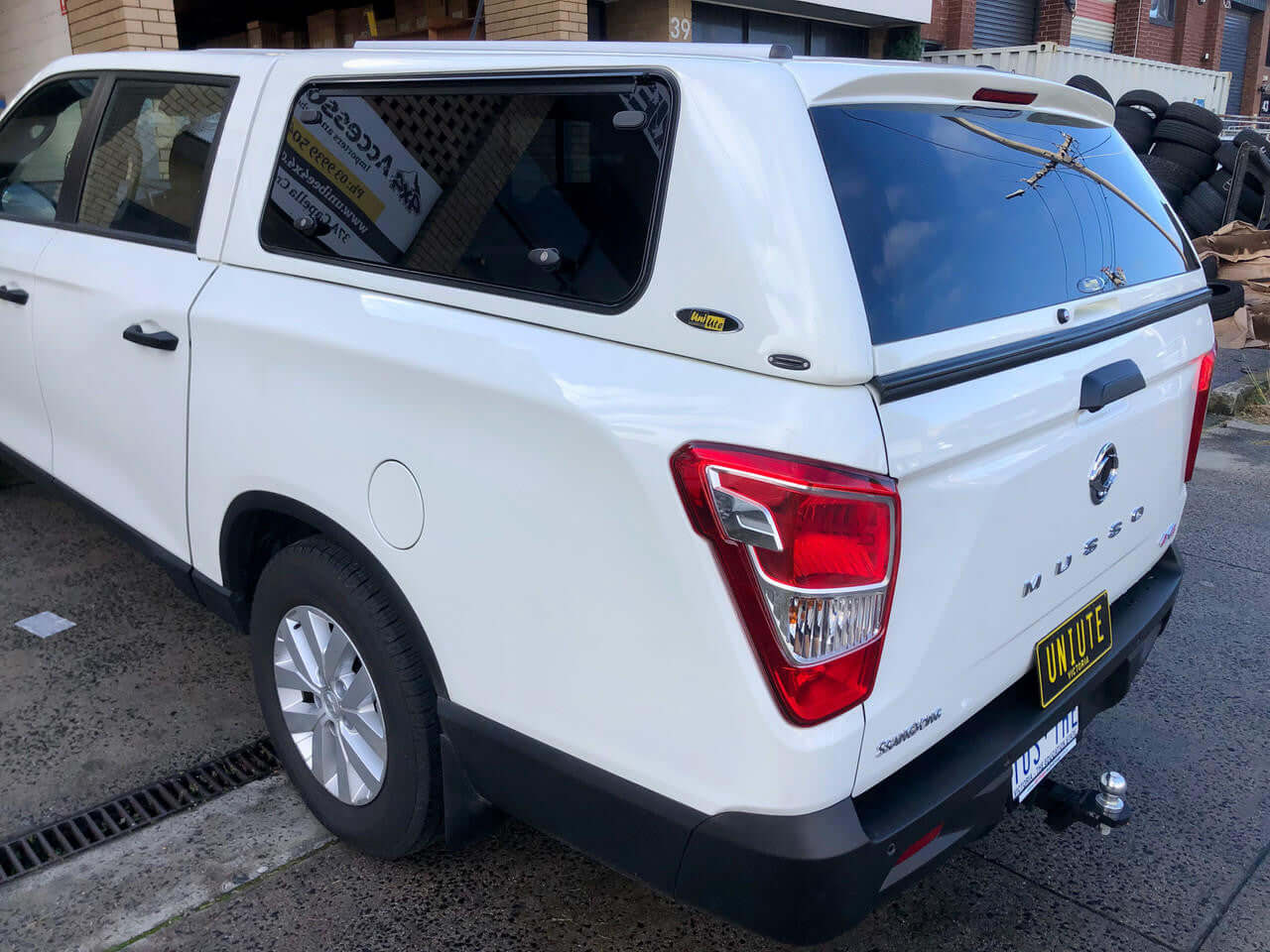 Rear view of a white SsangYong Musso XLV with FORCE PRO canopy for ssangyong musso from UniUte.