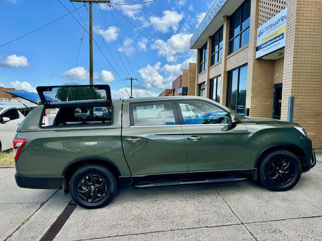 canopy for SsangYong Musso XLV 2018-2025 installed, green truck with open canopy in urban setting