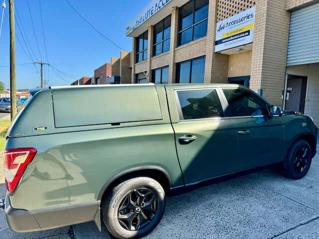 SsangYong Musso XLV Canopy on green pickup truck outside building