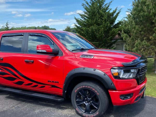 Red truck with black aftermarket 4x4 fender flares on a sunny day.