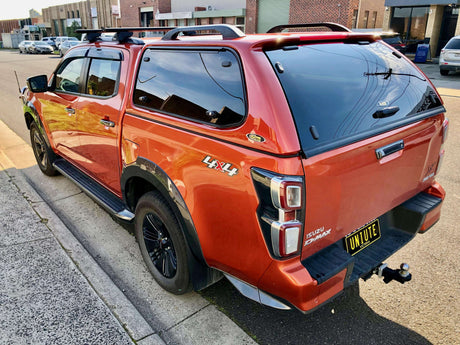 Red Isuzu D-Max 2024 parked on the street showcasing rear features and design.