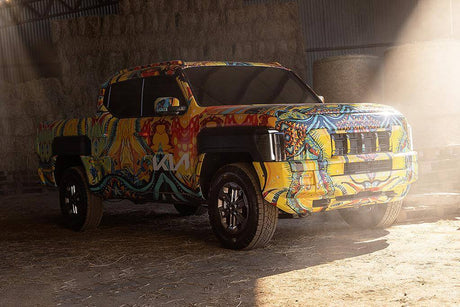Kia Tasman Ute parked in warehouse with colorful design, showcasing its innovative 4x4 features.