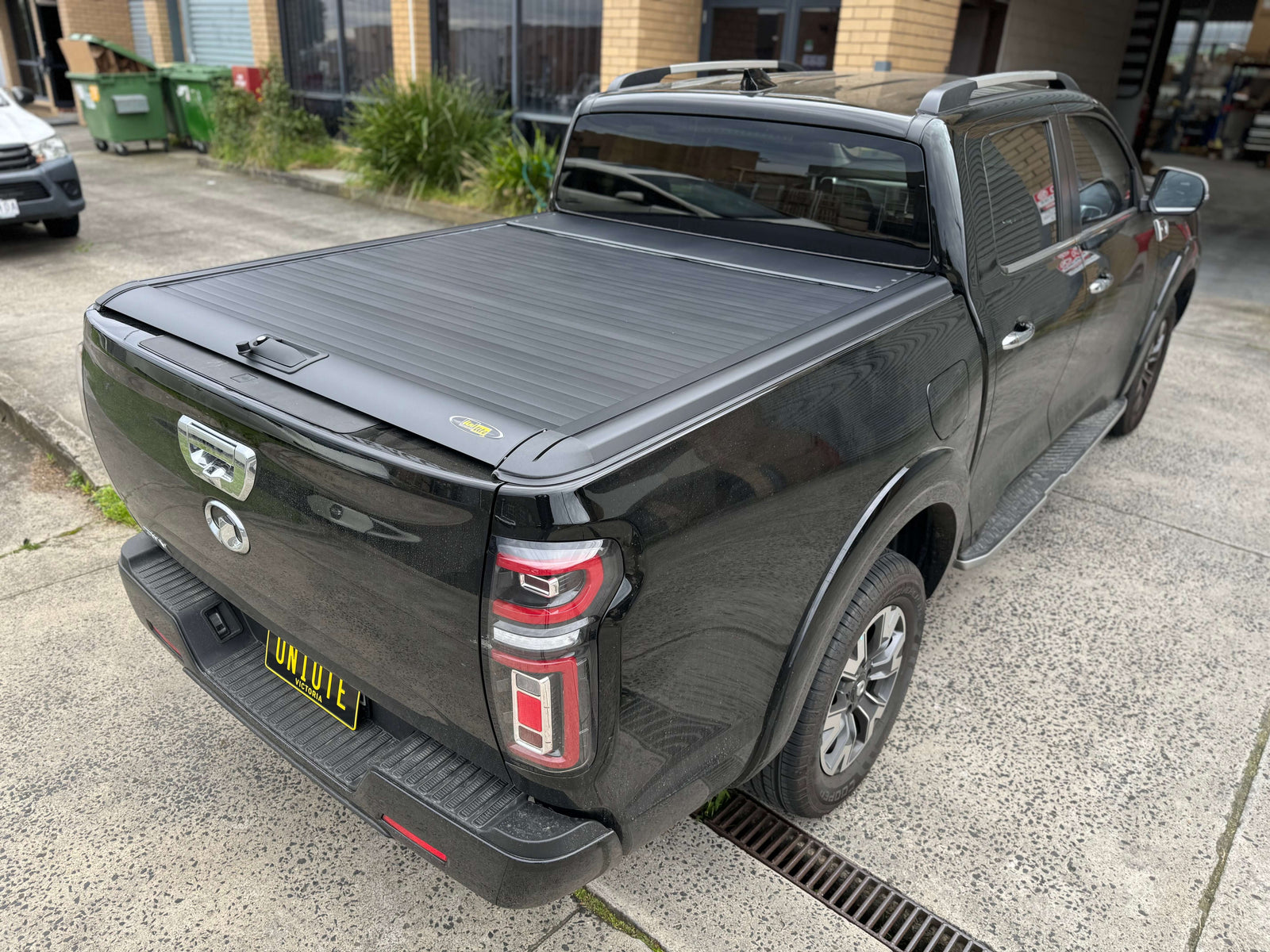 Sleek black GWM Ute parked outdoors, highlighting robust features ideal for everyday adventures.