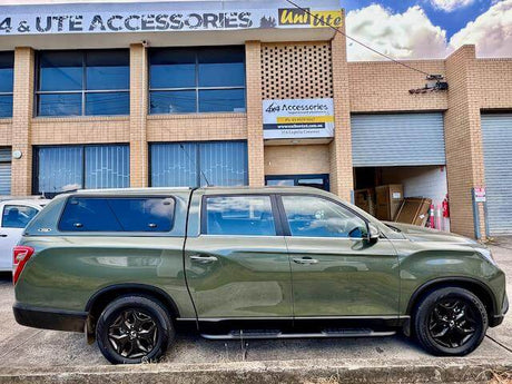 Green SUV parked in front of a 4x4 accessories shop, showcasing Four Wheel Drive Accessories Melbourne for ultimate off-roading.